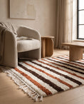 Load image into Gallery viewer, Brown, Terracotta and Cream striped wool rug in a furnished room
