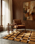 Load image into Gallery viewer, Brown, Cream and Ochre Yellow grid wool rug in a furnished room
