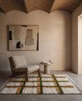 Load image into Gallery viewer, Olive Green, Ochre Yellow and Cream grid wool rug in a furnished room
