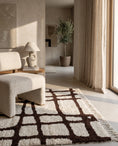 Load image into Gallery viewer, Brown and Cream grid wool rug in a furnished room
