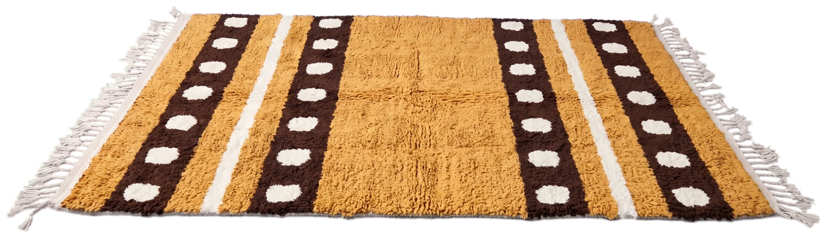 Dot Bands wool rug with bands in brown and cream on ochre, laid flat