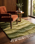 Load image into Gallery viewer, Moss, Sage and Olive Green wavy wool rug in a furnished room
