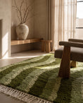 Load image into Gallery viewer, Moss, Sage and Olive Green wavy wool rug in a furnished room
