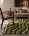 Load image into Gallery viewer, Moss, Sage and Olive Green wavy wool rug in a furnished room
