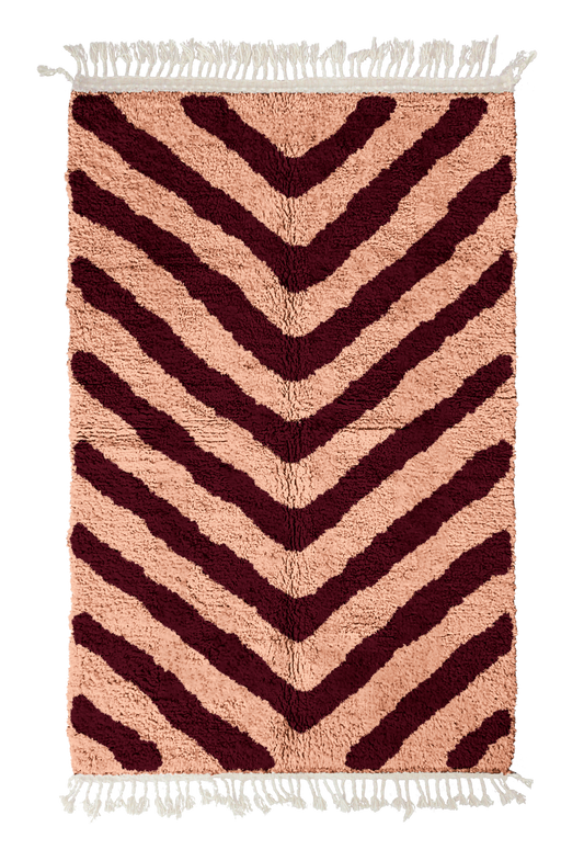 Arrow Stride zebra stripe wool rug, oxblood red stripes on blush pink, full view from above with fringed ends